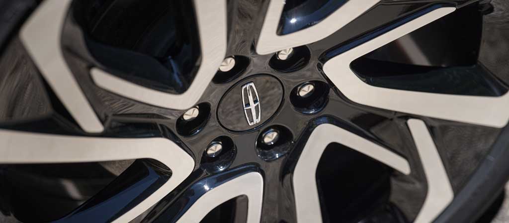 24" high-gloss Ebony Black-painted wheel with bright-machined finish on a 2027 Lincoln Navigator® Black Label™ model