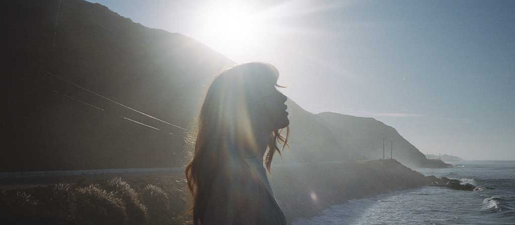 A woman enjoys a moment on a seaside overlook
