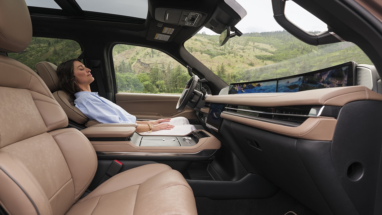 Woman relaxing in the driver's seat of a Lincoln vehicle experiencing a moment of calm.