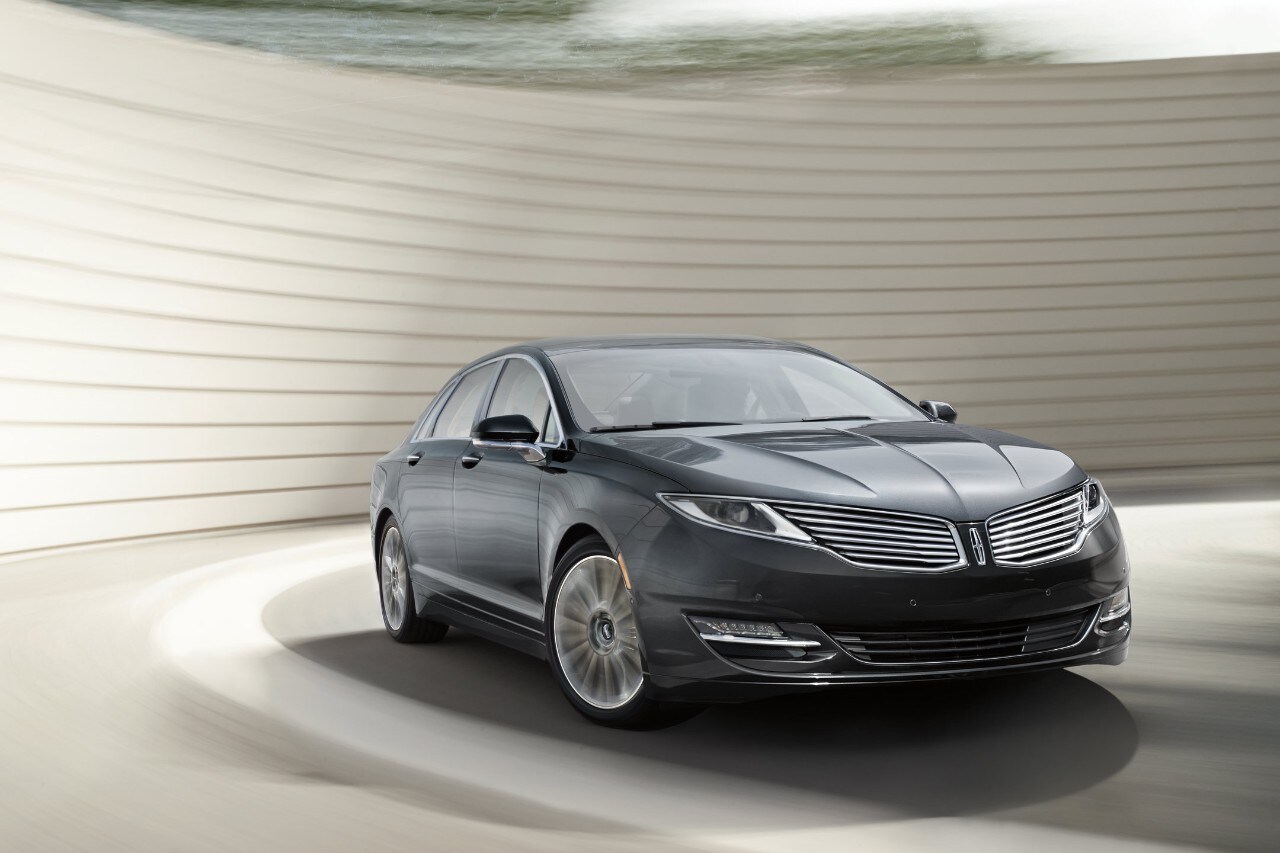 A Lincoln M K S in the Black Velvet exterior color is being driven around a corner