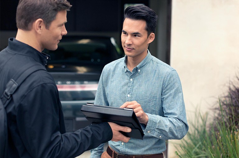 A Lincoln service representative is shown assisting a customer with his new Lincoln