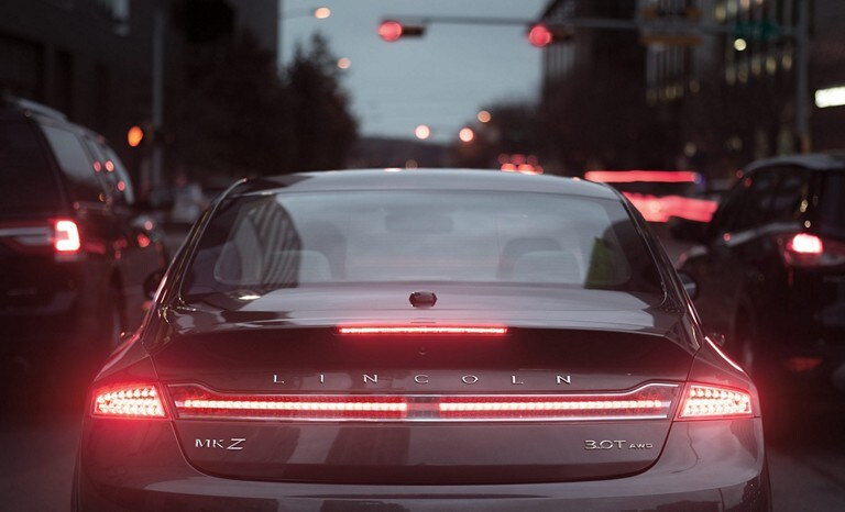 A black Lincoln M K Z in stop and go city traffic where the Rear View Adaptive Cruise Control with Stop and Go feature really shines