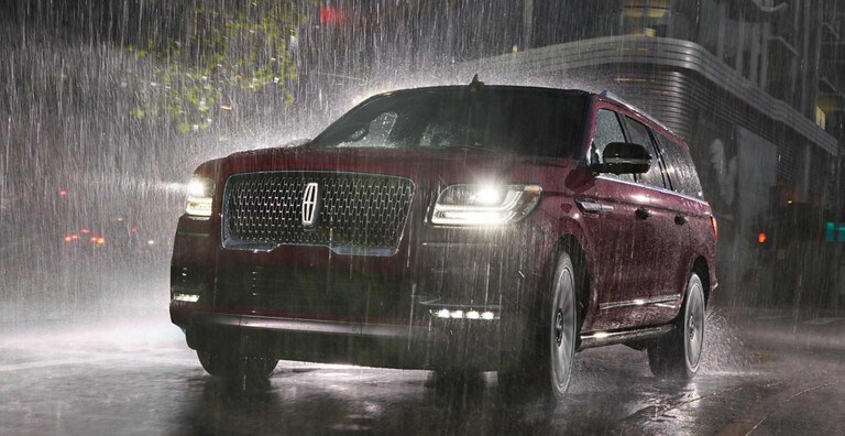 A red Lincoln Navigator in the rain at night using Rain Sensing Wipers
