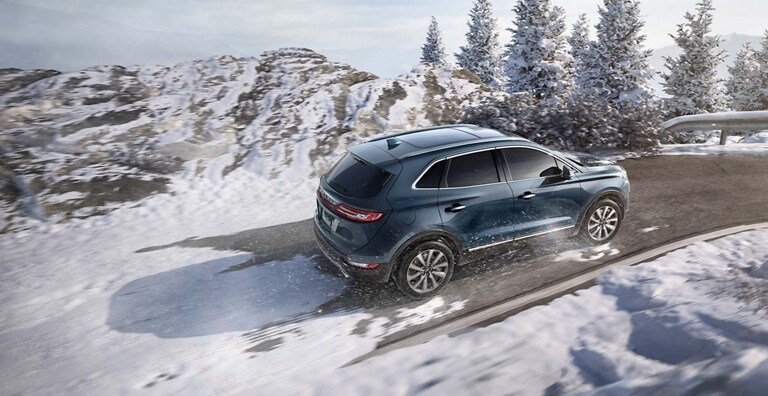A Lincoln crossover out in a snowy mountain road maintaining control with the Advancetrac with E S C feature