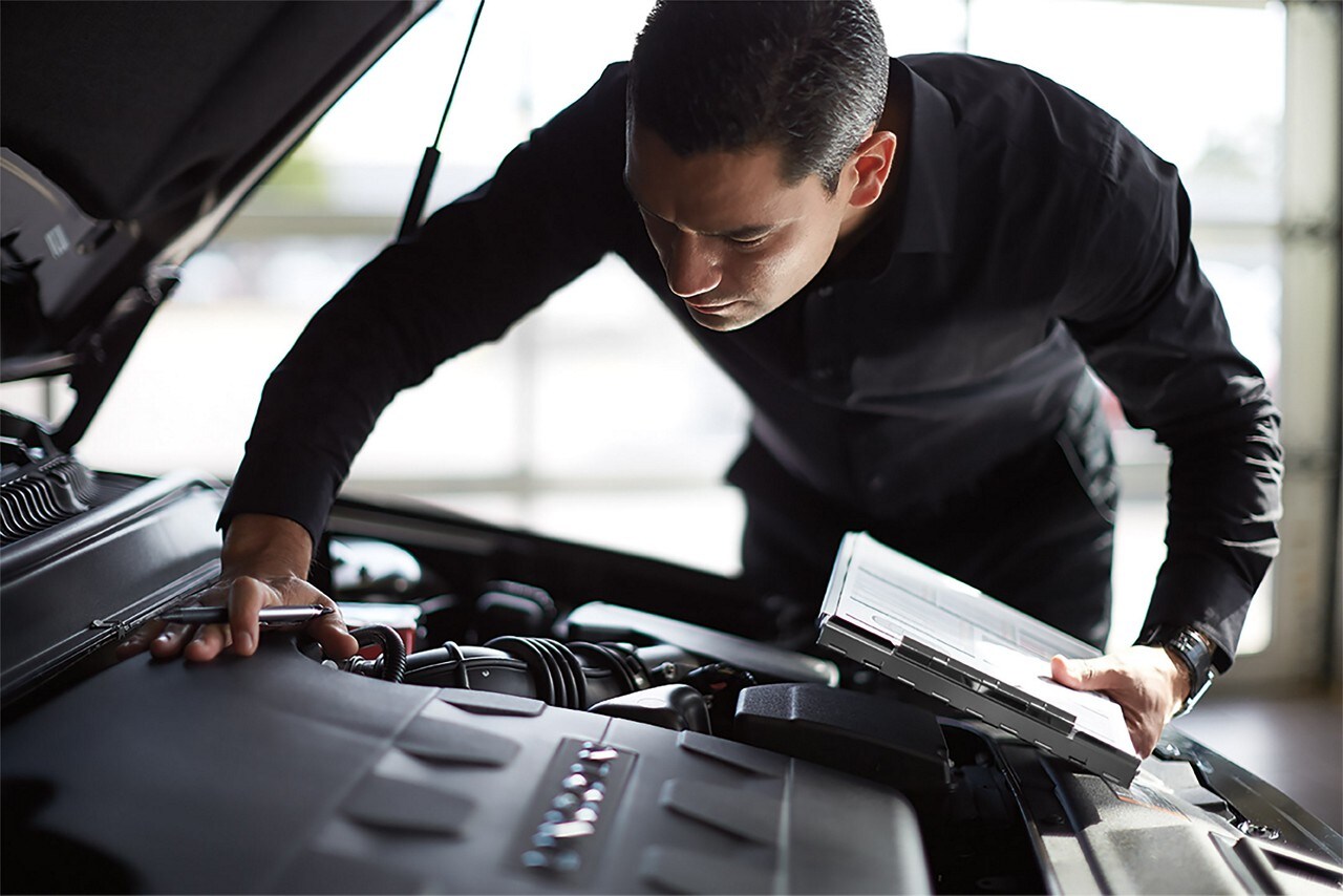 Lincoln service manager inspecting under the hood.