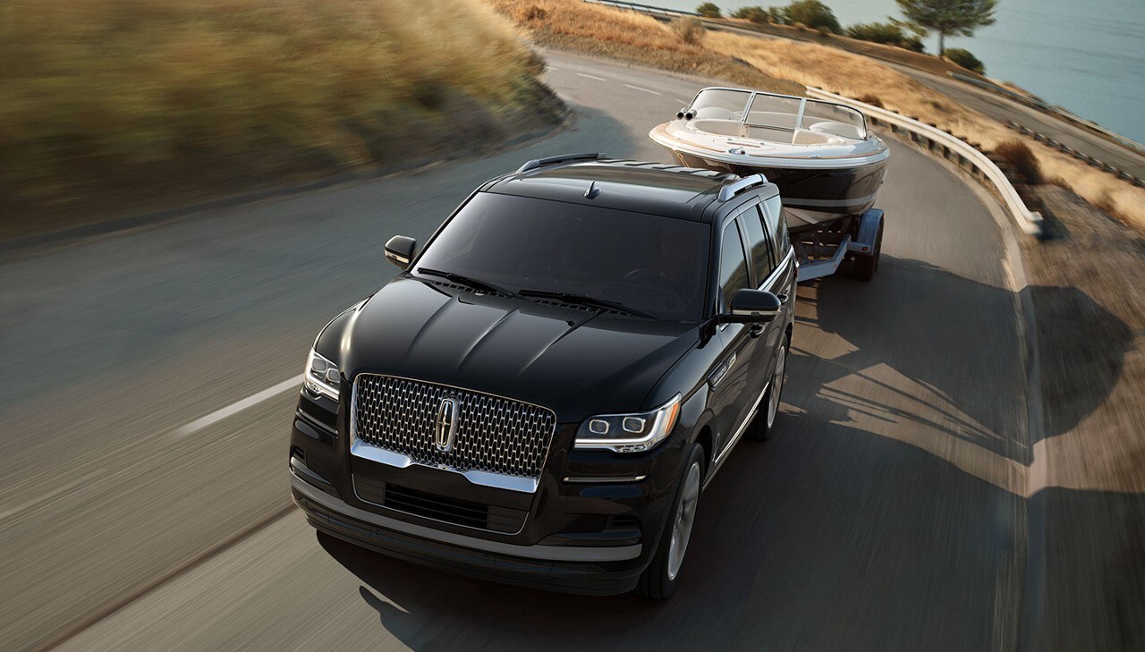 A Lincoln Navigator towing a boat.