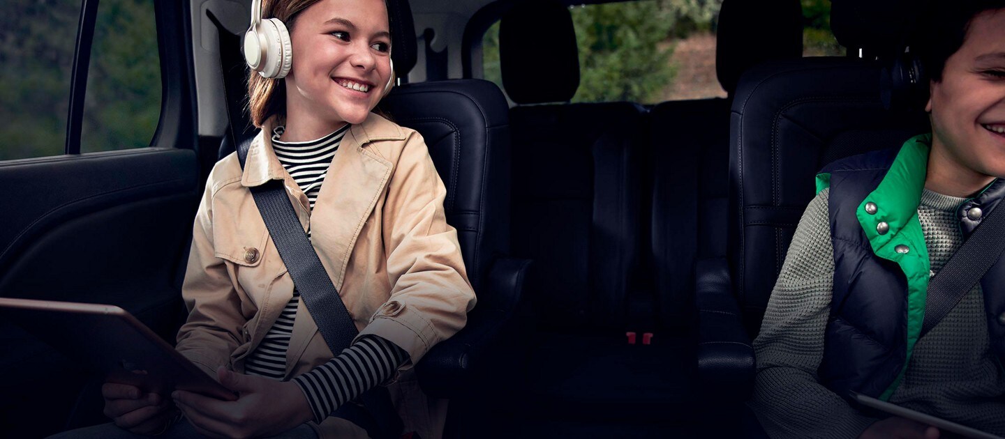 Two children are comfortably seated in the second row of a 2023 Lincoln Aviator®