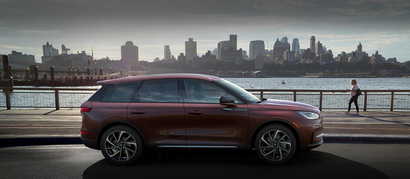 A 2023 Lincoln Corsair SUV is parked next to a riverside park.