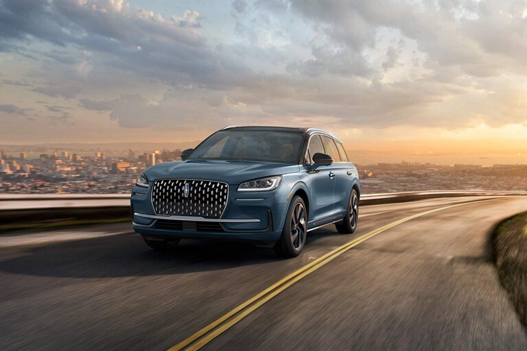 A 2023 Lincoln Corsair Grand Touring model is being driven on a hillside road