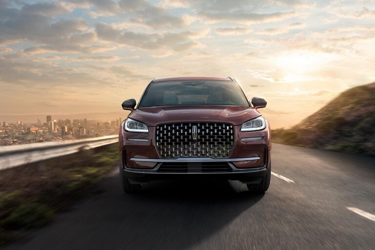 A 2023 Lincoln Corsair is being driven through an urban setting at night with responsive performance