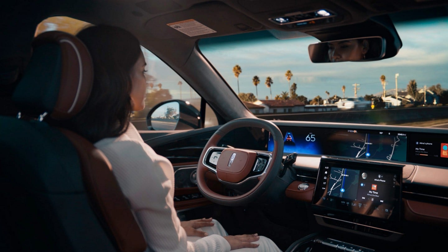 A driver of a 2024 Lincoln Nautilus SUV is shown using Lincoln BlueCruise hands-free highway driving technology