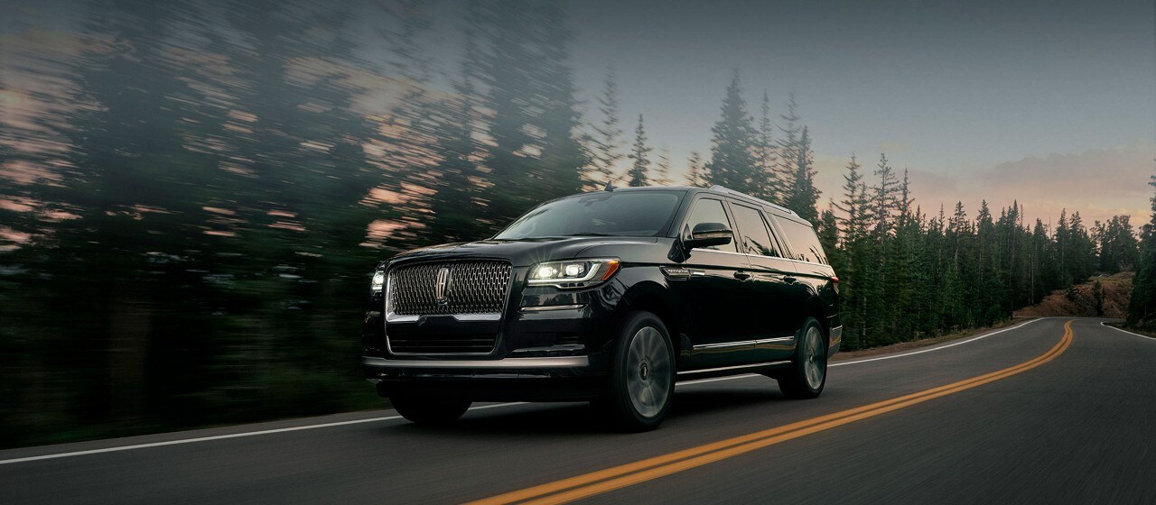 2023 Lincoln Navigator being driven down a road with forest in the background