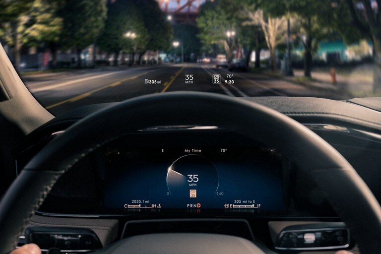 Head-Up Display information is being projected above the steering wheel at night