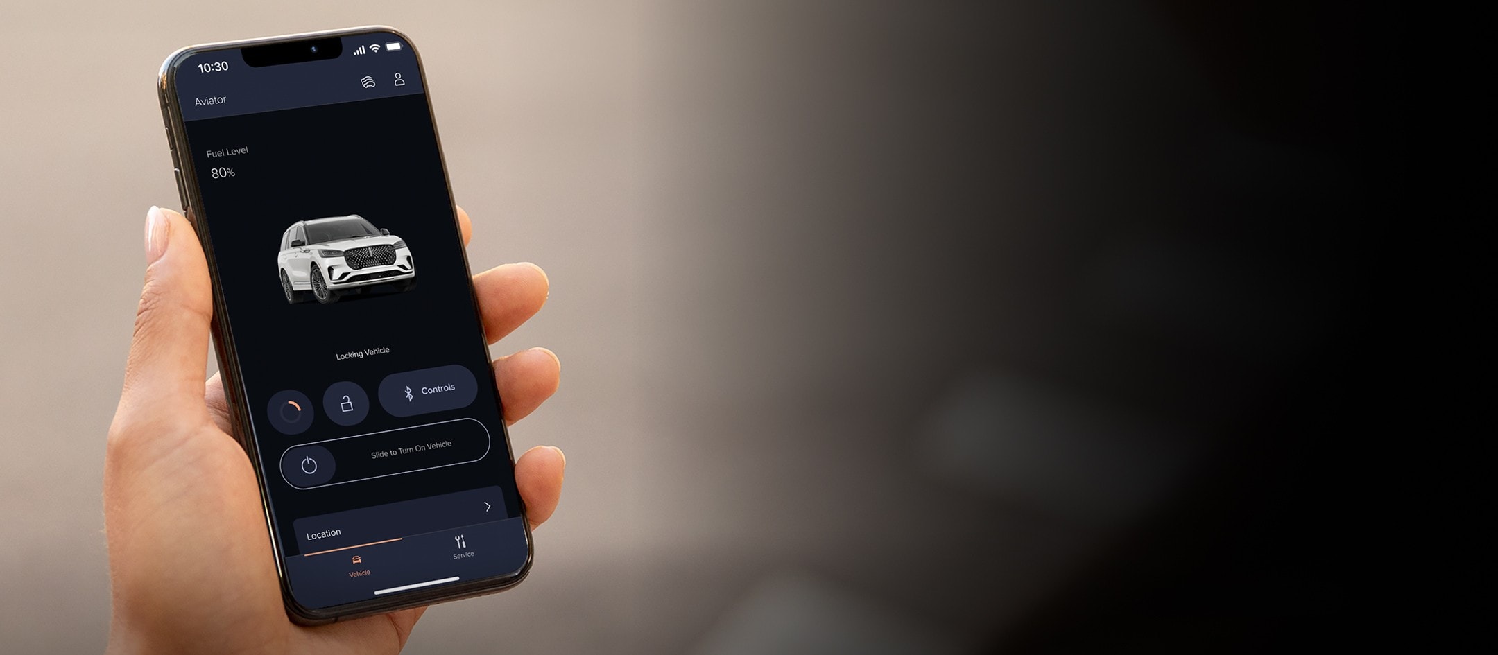A woman is standing at a sunny window interacting with the Lincoln Way app on her smartphone device