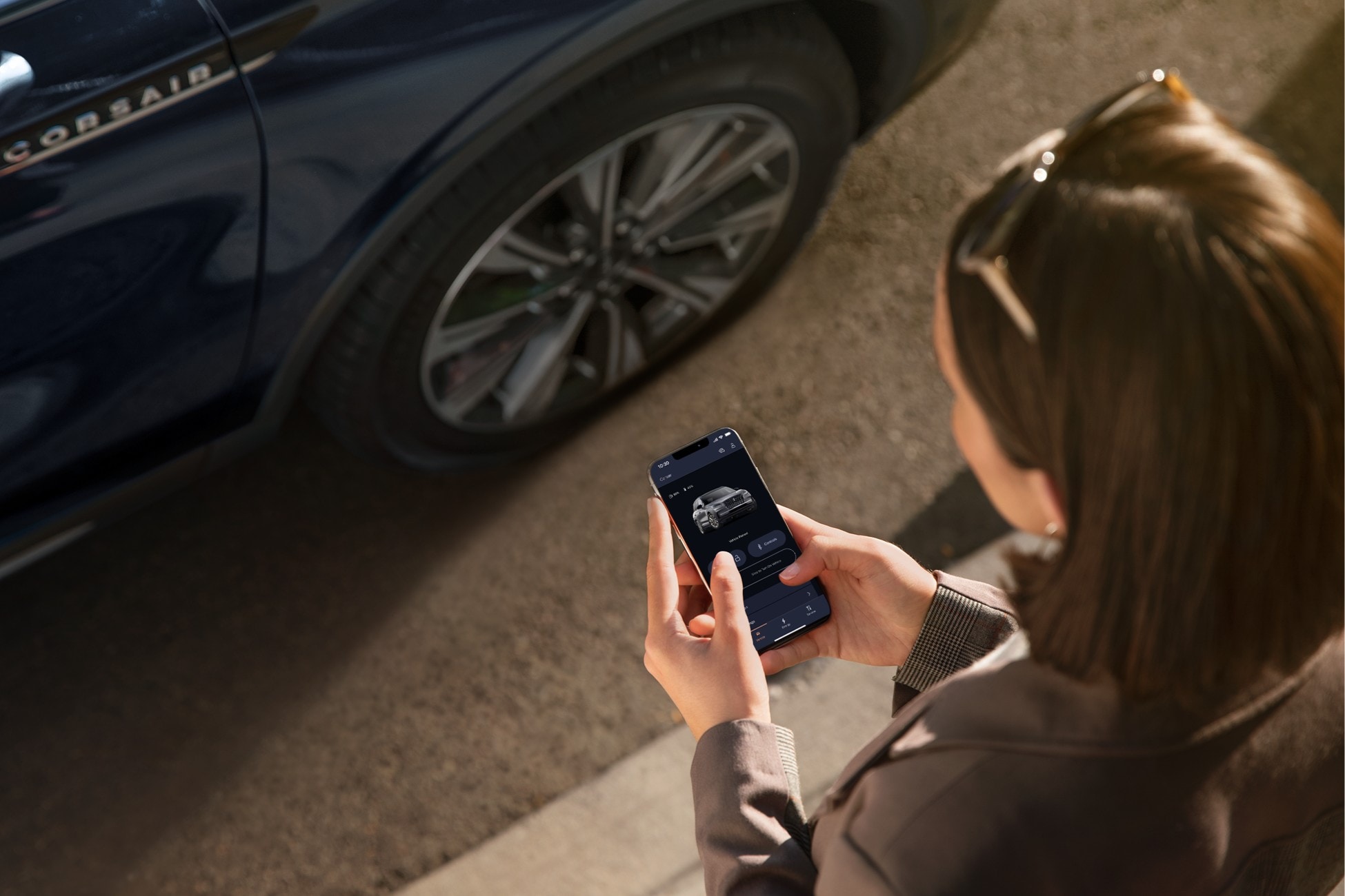 A person uses a mobile phone to interact with the Lincoln app