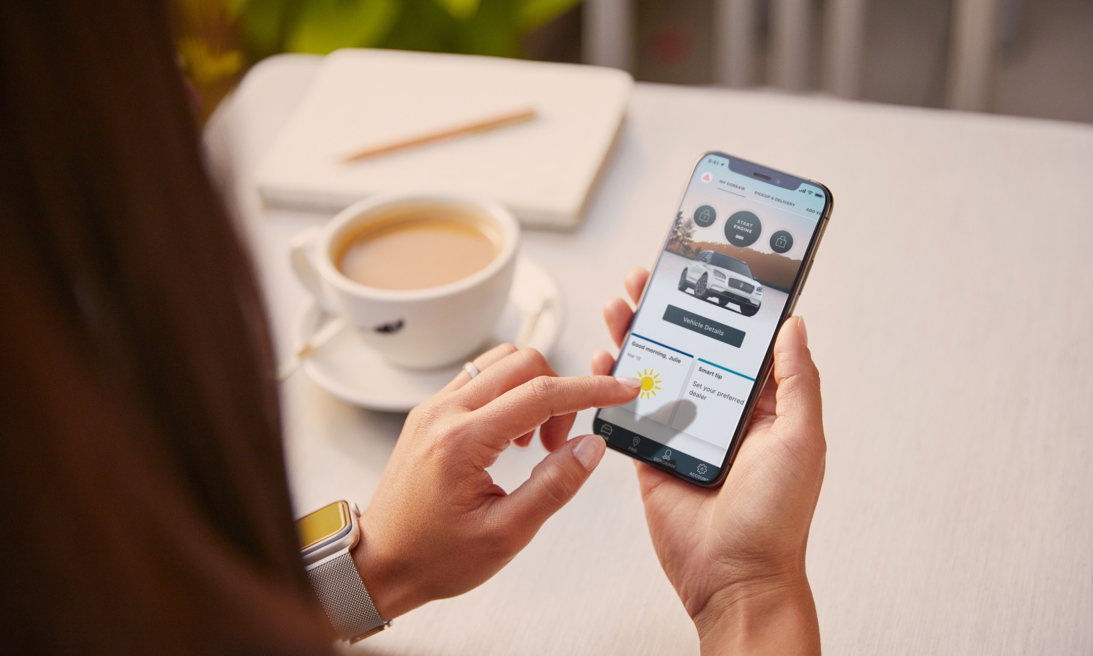 Someone is using the Lincoln Way App on their smartphone seated at a table while having a coffee at a cafe