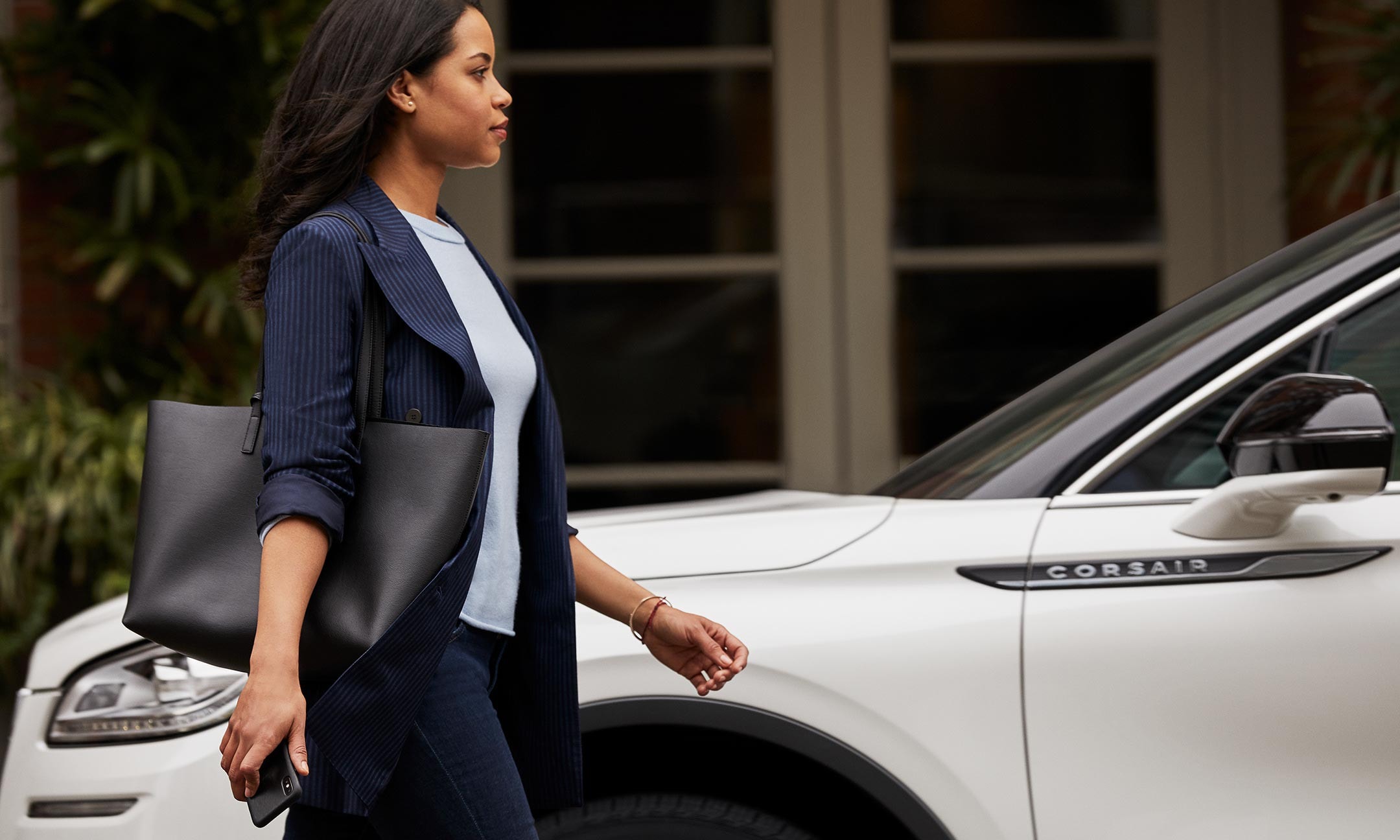 A person is shown approaching a Lincoln Corsair demonstrating how phone as a key works