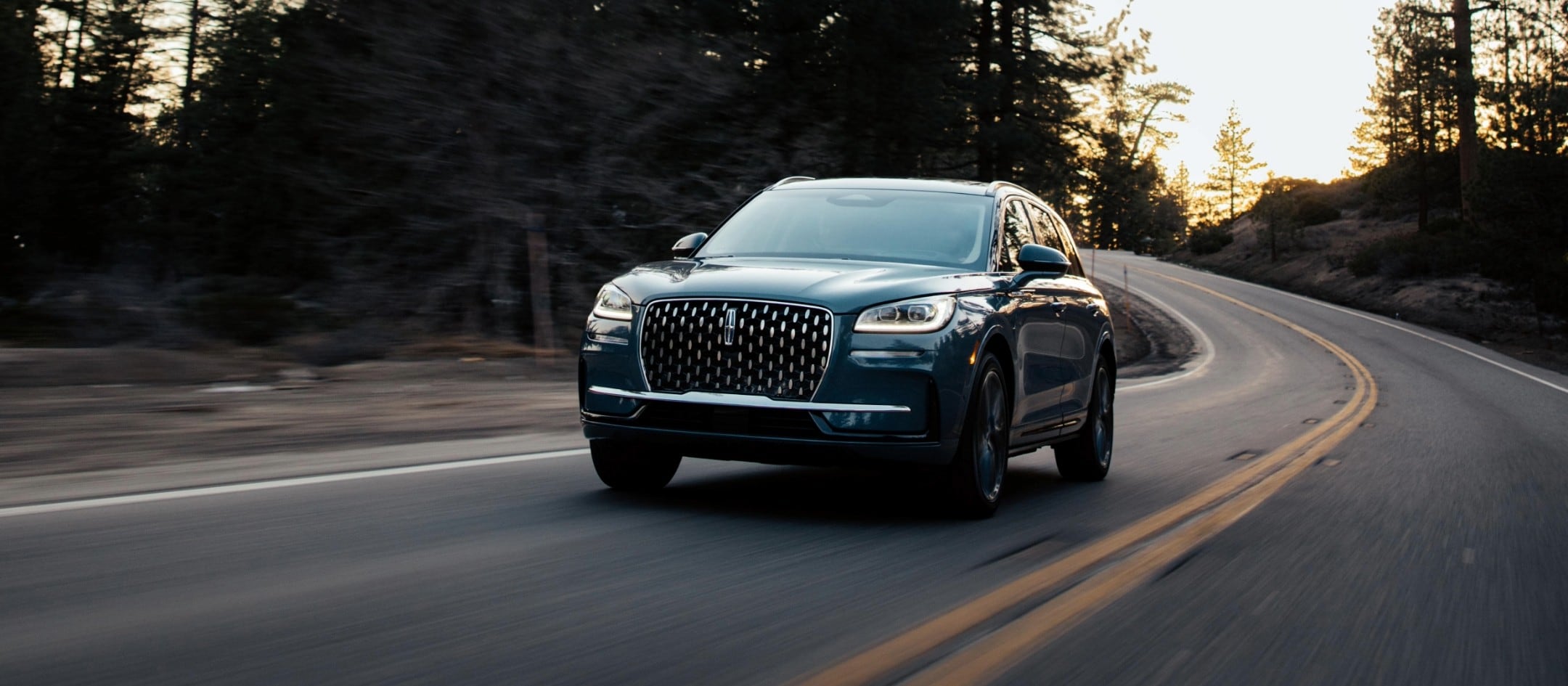 A Lincoln Nautilus is being driven along a country road