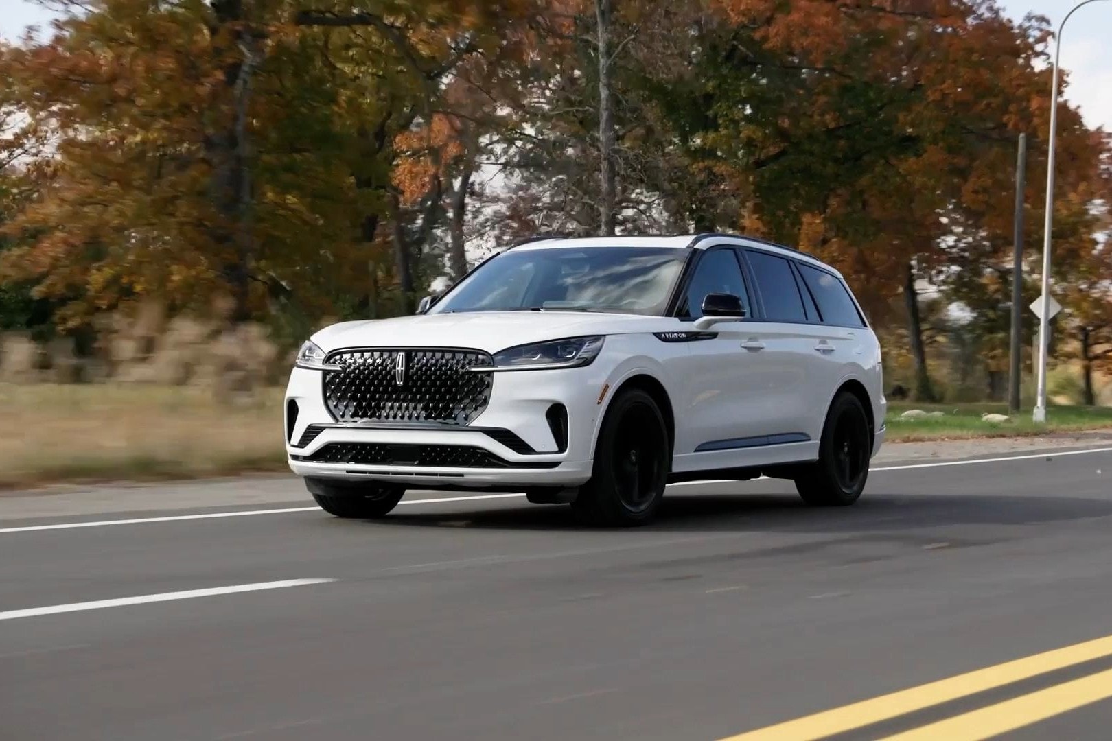 A 2025 Lincoln Aviator is shown being driven along a road.