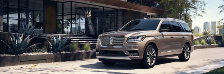 Lincoln Navigator 2019 en moka glacé stationné dans l’allée devant une grande maison