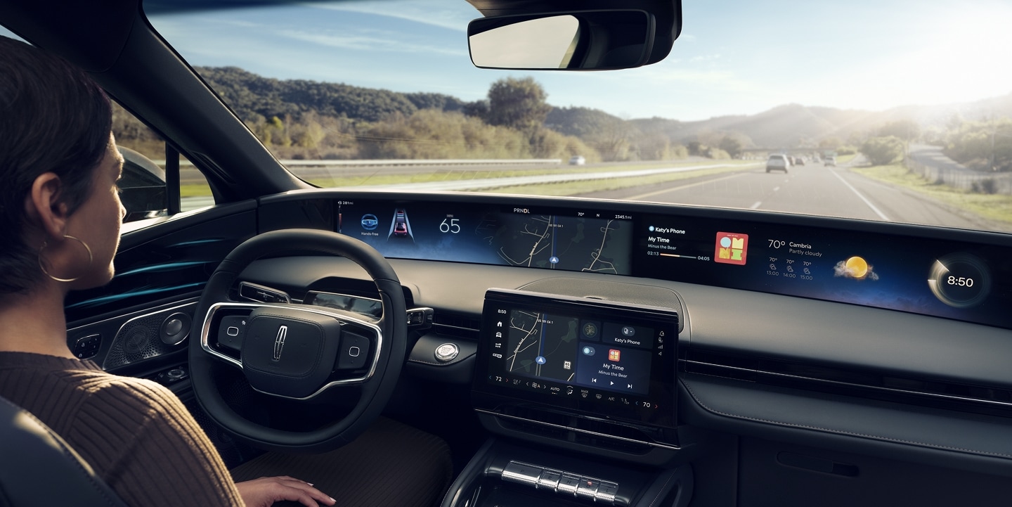A woman is shown driving Lincoln Nautilus SUV hands-free using Lincoln BlueCruise on a highway.