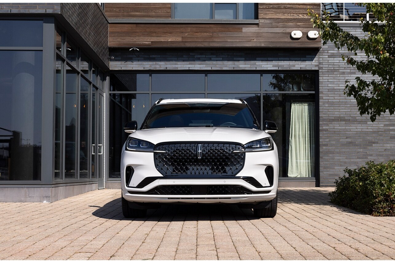 A 2025 Lincoln Aviator® SUV is parked in front of a modern home.