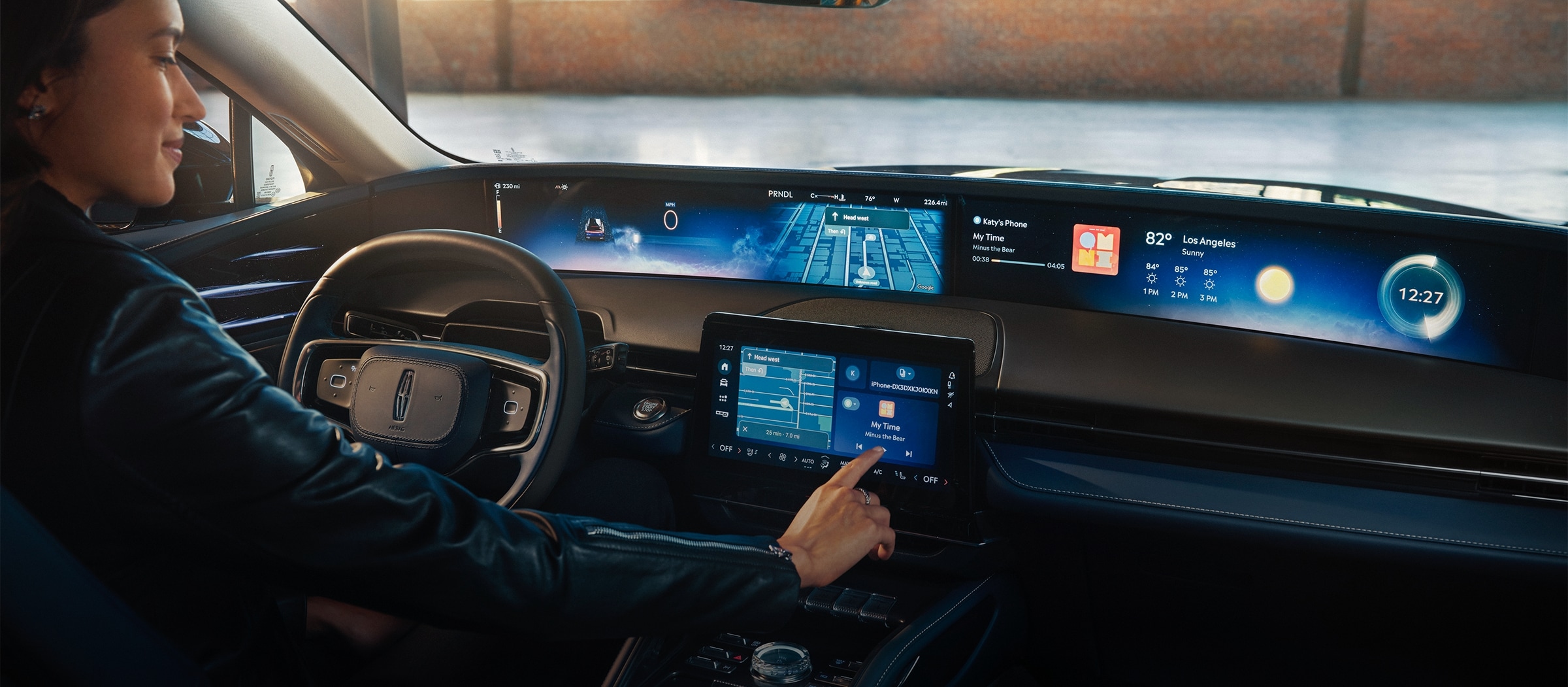 A woman is shown in the driver’s seat of a Lincoln Nautilus® SUV touching the centre-stack display.