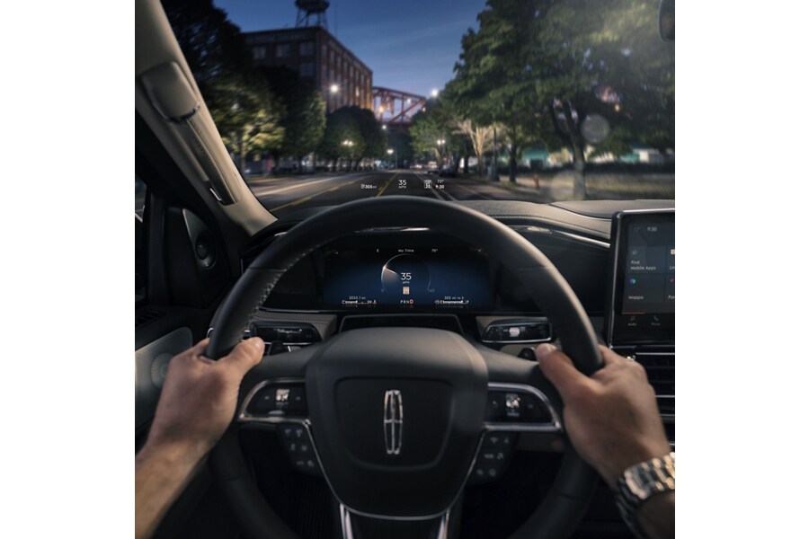 Two hands grip a steering wheel