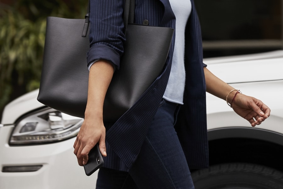 A person is shown approaching a Lincoln vehicle with their smartphone in their hand