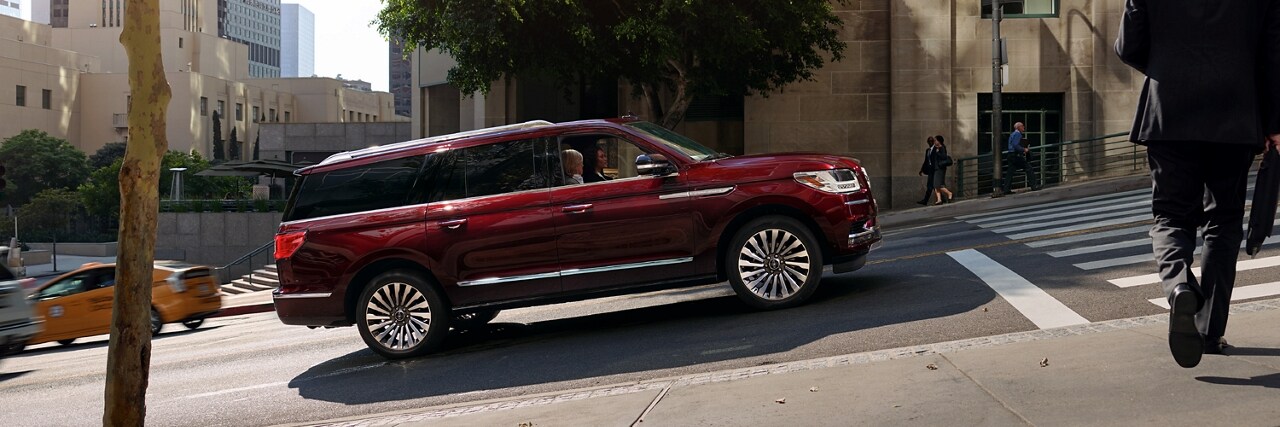 a Lincoln vehicle stopped on a street with a steep incline is shown here