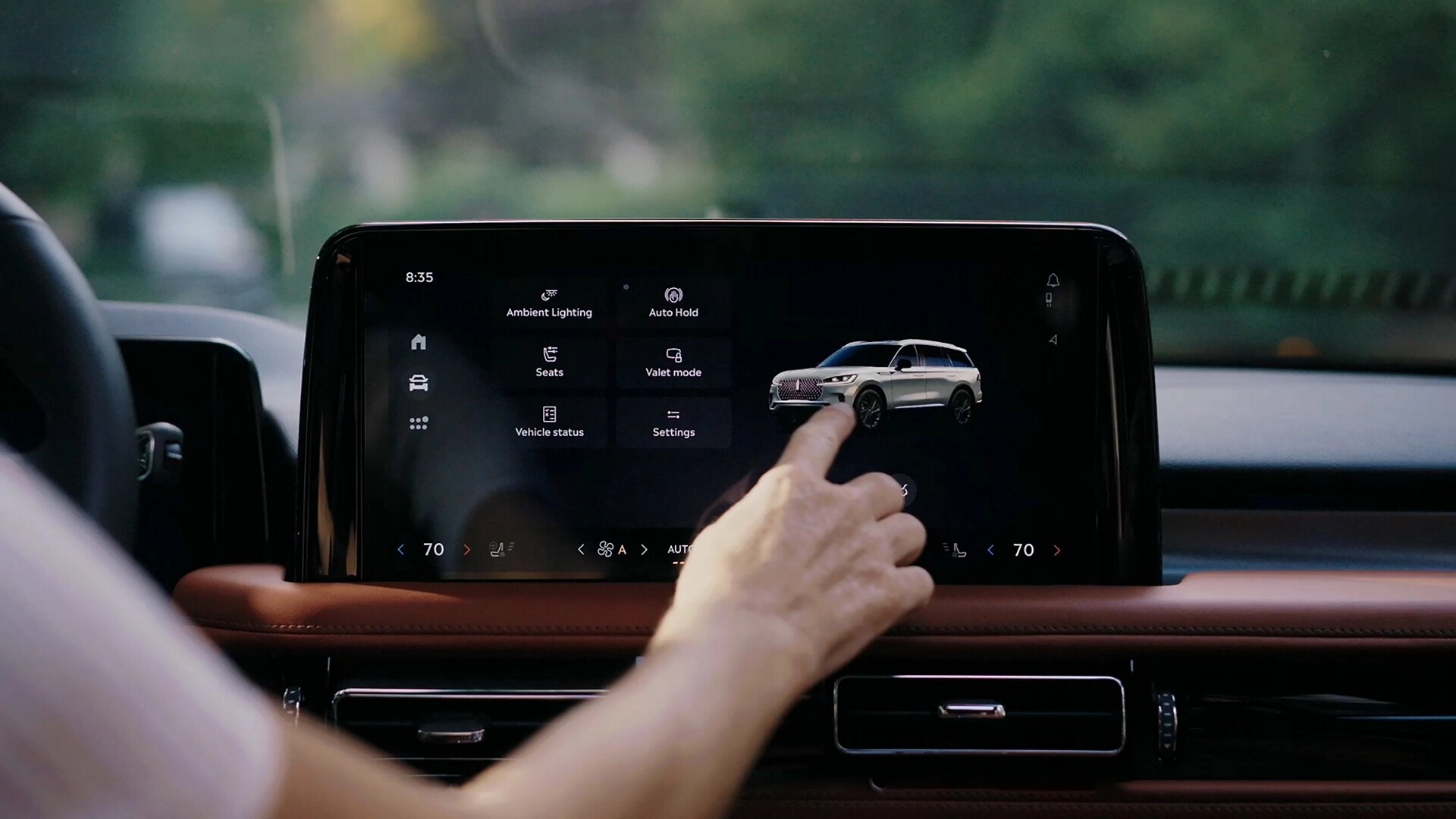 A person touches the centre touchscreen to activate the power liftgate of a 2026 Lincoln Aviator