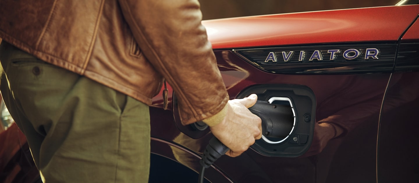 Man charging his Lincoln Aviator