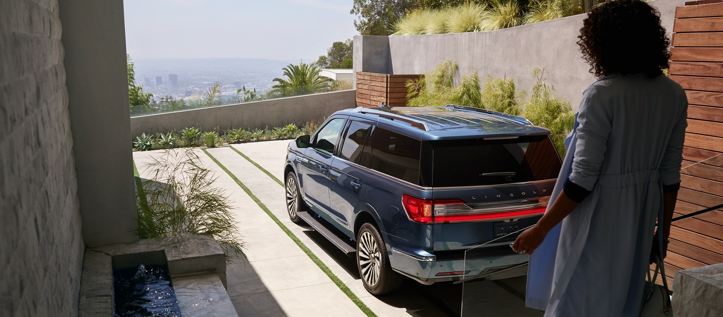A woman outside a loft approaches a 2021 Lincoln Navigator as the recognition capabilities of the Personal Profiles system are already engaging