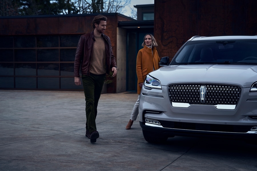 Man and woman approach a 2023 Lincoln Aviator® with Approach Detection Welcome Lighting