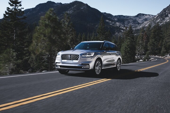2023 Lincoln Aviator® Grand Touring model being driven on a tree-lined road