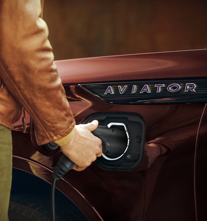 Person disconnecting the at-home charger from a 2023 Lincoln Aviator®