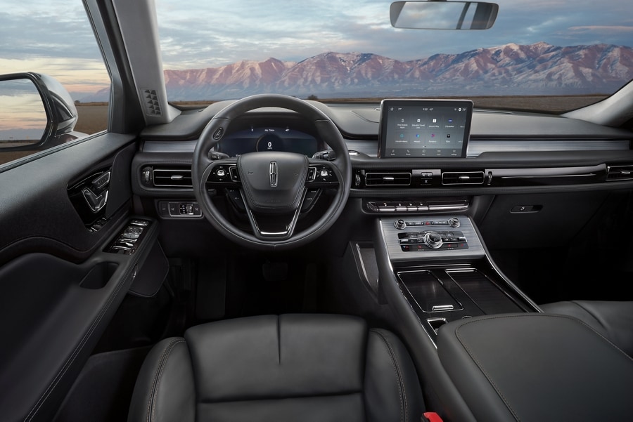 Front cabin of a 2023 Lincoln Aviator® with a remote mountain range seen through the Acoustic-Laminate Windshield