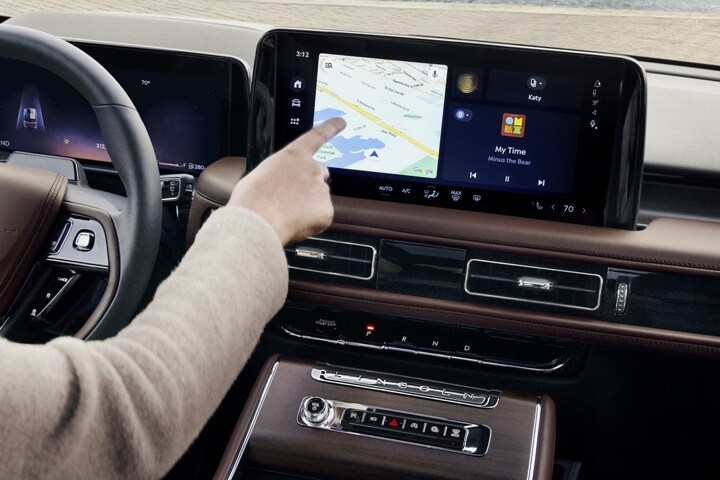 A person is tapping the centre-stack touchscreen display of a 2025 Lincoln Aviator