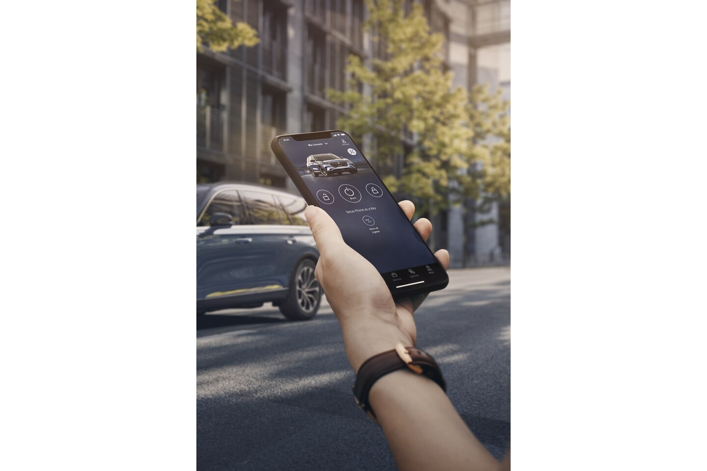 A person holds a smartphone as they approach a Lincoln vehicle