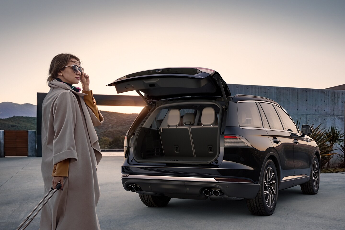 A woman approaches a 2025 Lincoln Aviator with its rear liftgate open