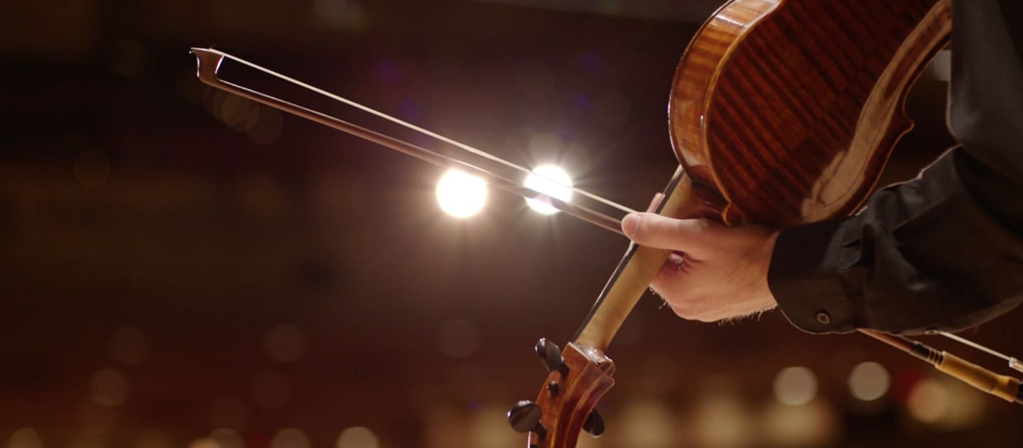 A bow slides across a violin to illustrate the dramatic sound of the in vehicle chimes