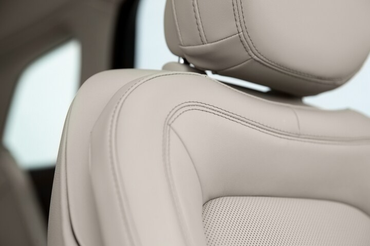 A detail shot of a leather trimmed Perfect Position front seat shows details like luxe materials and precision stitching