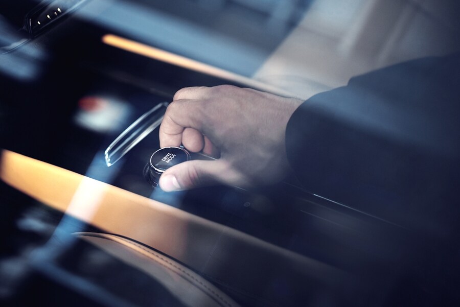 Through the window of a 2023 Lincoln Corsair SUV we see a hand turning the drive modes knob