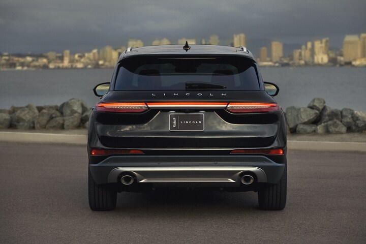 The bold strip of rear LED lights stands bright against a flight blue exterior and a city fading into night
