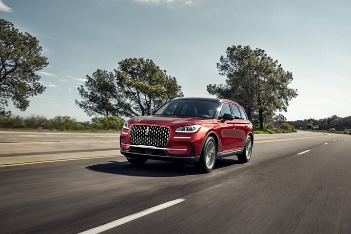 A 2023 Lincoln Corsair SUV is shown being driven in a rural setting