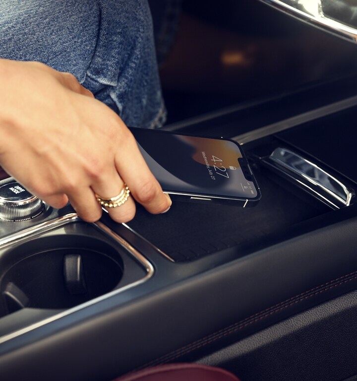 A mobile phone is being placed on the wireless charger of a 2023 Lincoln Corsair SUV