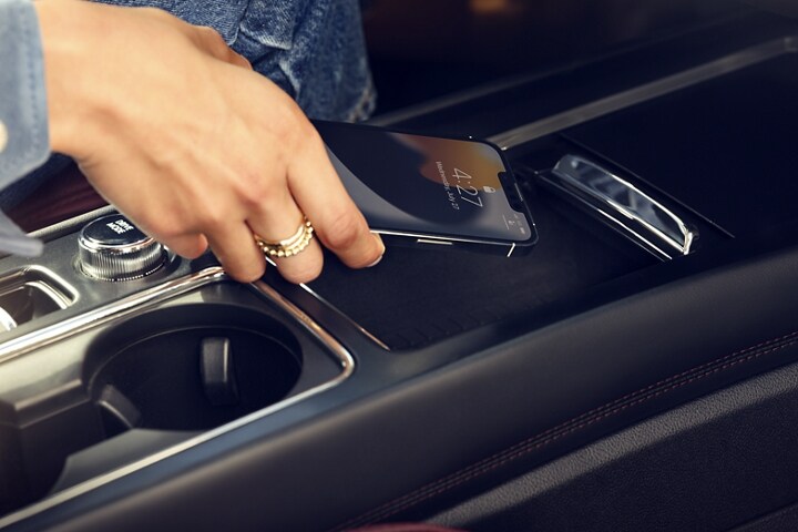 A smartphone device is securely tucked into the wireless charging pad for an effortless energy boost
