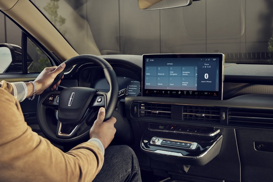 A person is shown sitting in the driver’s seat of a 2023 Corsair SUV while adjusting their personal profiles settings