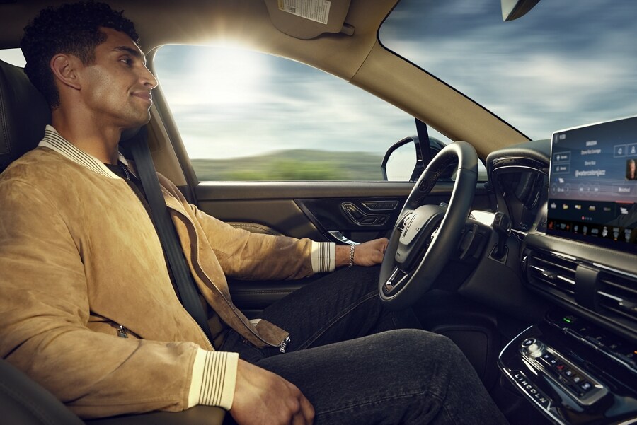 A man is shown utilizing hands-free ActiveGlide™ 1.2 driving while paying attention to the road ahead