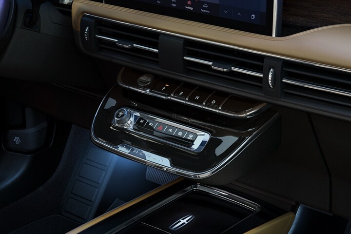 The park button on the elegant piano key shifter is lit up and engaged as light dances off the chrome accents